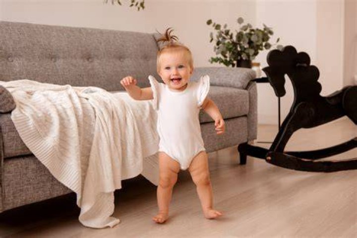 What age do babies walk along furniture?